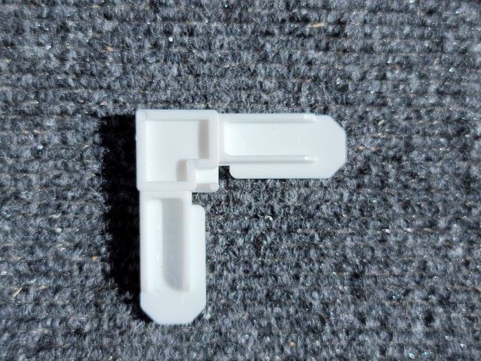 Top view of 5/16 white plastic window screen corner
